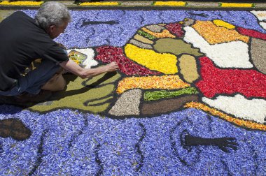 La Orotava, Tenerife, Kanarya Adaları, İspanya - 11 Haziran 2015: yerel sanatçı Corpus Christi halı üzerinde geleneksel görüntü çalışma renkli volkanik kum ve çiçek yaprakları her yıl oluşturulan