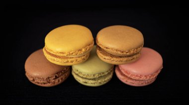Geleneksel Fransızca macaroons veya macarons, farklı renk ve lezzetleri, çok hafif lokma şekerci, seçim ürün yelpazesine yığılmış ve siyah arka plan ve seçici odak karşı izole
