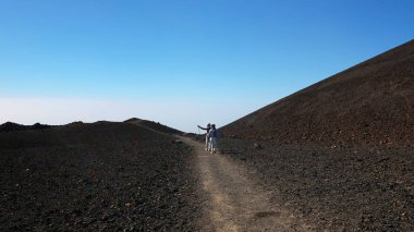 Montana Samara, Teide Milli Parkı, Tenerife, Kanarya Adaları, İspanya - 13 Ocak 2019: yaşlı çift, kadın ve trekking direkleri ile kadın, en sıradışı, yabancı volkanik manzara ile yürüyüş