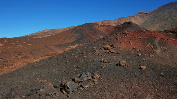 Unusual lunar landscape of the volcanic remains in Teide National Park, with rocky lava, red gravel and no vegetation, concept for life origin, environmental impact of the elements or live extinction