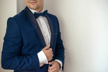 Koyu mavi smokin, beyaz gömlek ve papyon, sofistike iş adamları veya zengin ve başarılı bin yıllık adam için kavram moda yakışıklı Kafkas erkek modeli portresi hazırlanıyor