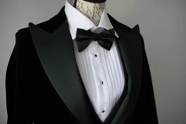 Cropped shot of elegant black tie suit with white shirt and silk bow tie on  mannequin torso or a dress form, sartorial accessories for formal attire, classy groom or a sophisticated business person