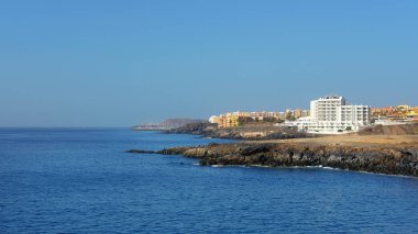 Yaz, Tenerife 'deki popüler güney tatil beldeleri San Blas ve Golf del Sur' a doğru açık manzaralar, Los Abrigos, Tenerife, İspanya 'daki küçük balıkçı köyünde Playa Grande' den görüldüğü gibi.