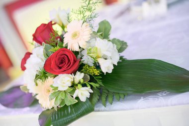 Kırmızı güller, pastel Gerbera papatyaları ve yeşillikler içeren güzel çiçek centerpieces ile resepsiyon mekan veya restoranda gelin ve damat veya misafirler için romantik düğün dekor