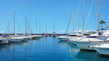 Puerto Colon, Costa Adeje, Tenerife, Canary Islands, Spain - April 5, 2019: yachts, sailboats and catamarans moored alongside the busiest marina with a capacity for 364 anchored boats and 237 moorings clipart