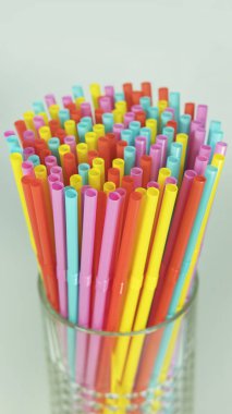Çok renkli plastik içme pipetleri nötr bir arka plan aleyhine bir arada tuttu. Tek kullanımlık esnek pipetler, okyanusların kirlenmesine neden olan, deniz kuvvetlerine zarar veren, biyolojik olarak ayrışması veya çözülmesi zor.