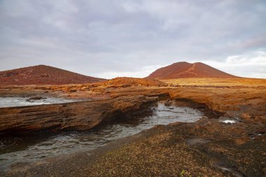 Montana Roja Özel Doğal Rezerv, alışılmadık bir volkanik koni üzerinde bulutlu gündoğumu, adada inorganik kum habitatları en iyi örneklerinden biri, El Medano, Tenerife, Kanarya Adaları, İspanya