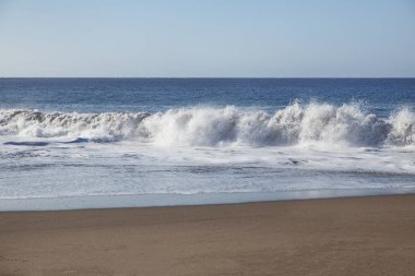 Playa La Tejita 'da fren yapan köpüklü büyük dalgalar, Montana Roja Doğa Rezervi yakınlarında, bir kilometre uzunluğunda vahşi ve sakin bir plaj, su sporlarının gözde bir eğlencesi, Tenerife, Kanarya Adaları, İspanya