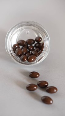 Kahverengi selenyum vitamin takviyelerinin, kalp hastalığı ya da kanser gibi hastalıkları önlediği düşünülür. Cam bir kaseye konur ve gri bir zemin üzerine dökülür.