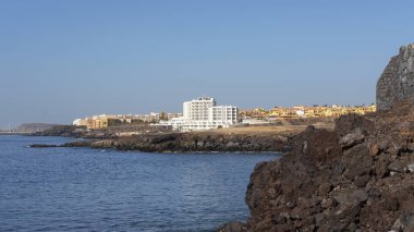Yaz, Tenerife 'deki popüler güney tatil beldeleri San Blas ve Golf del Sur' a doğru açık manzaralar, Los Abrigos, Tenerife, İspanya 'daki küçük balıkçı köyünde Playa Grande' den görüldüğü gibi.