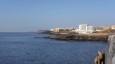 Yaz, Tenerife 'deki popüler güney tatil beldeleri San Blas ve Golf del Sur' a doğru açık manzaralar, Los Abrigos, Tenerife, İspanya 'daki küçük balıkçı köyünde Playa Grande' den görüldüğü gibi.