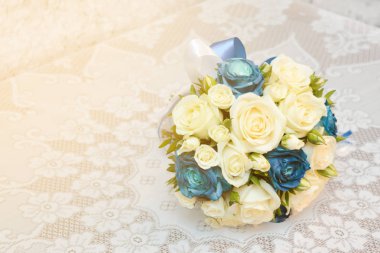 Mavi ve sarı güller ile beyaz masa örtüsü güneş ışığı ile bir masada buket düğün