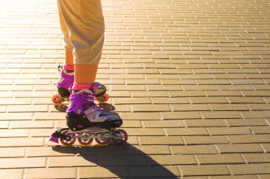 Patenci eylem kapatın. İçinde belgili tanımlık geçmiş güneş ışını ile tekerlekli paten Ayakkabı.