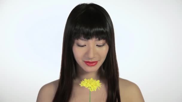 年轻女人闻朵花和微笑 — 图库视频影像