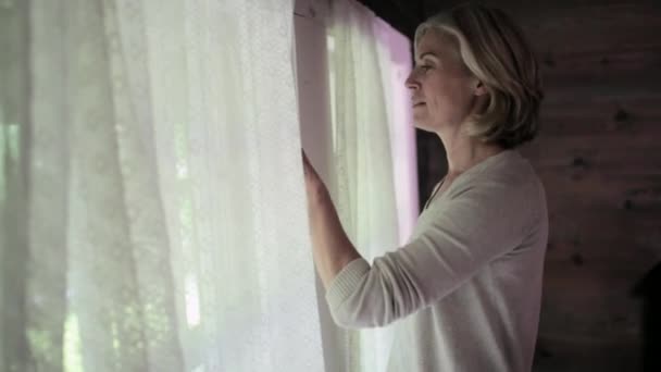 Gammal Kvinna Tittar Genom Fönstret — Stockvideo