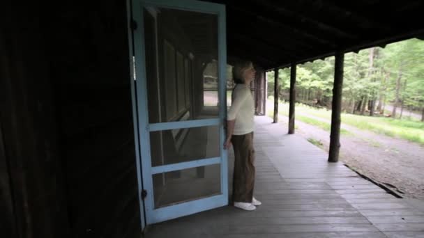 田舎の隠れ家でポーチに歩く中高年のカップル — ストック動画