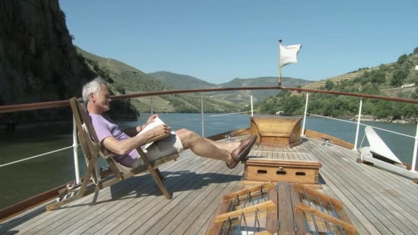 Hombre Mayor Leyendo Libro Barco — Vídeos de Stock