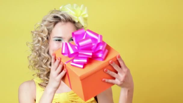 黄色背景的生日礼物的年轻妇女 — 图库视频影像