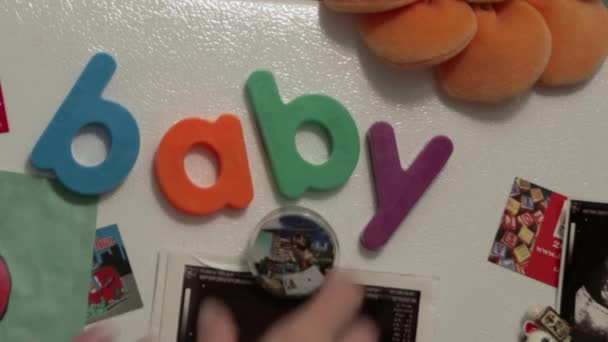 冰箱磁铁拼写婴孩和人交换磁铁 — 图库视频影像