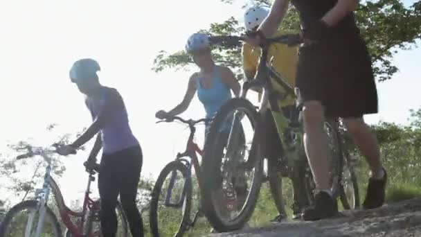 Quatro Ciclistas Empurrando Bicicletas Sobre Rochas — Vídeo de Stock