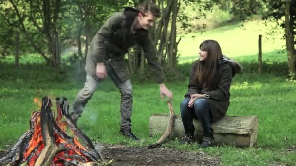 Junges Paar Sitzt Auf Baumstamm Lagerfeuer — Stockvideo