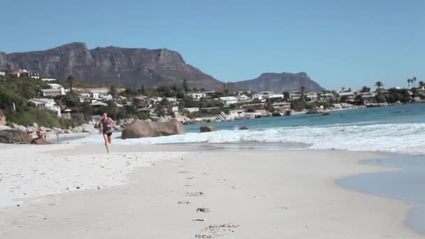 Vista Frontale Del Giovane Uomo Che Jogging Sulla Spiaggia — Video Stock