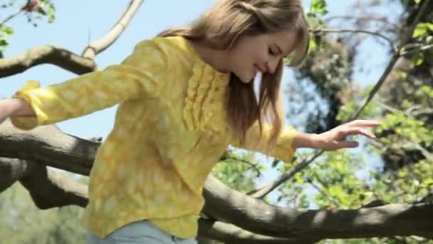 树上的年轻女子和人在树干上雕刻心脏 — 图库视频影像