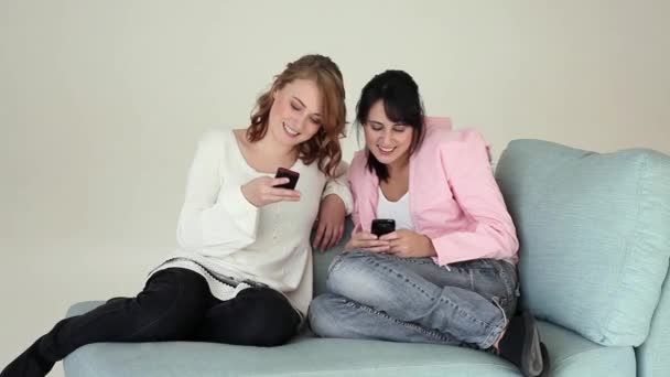 两名青少年在沙发上使用智能手机 — 图库视频影像