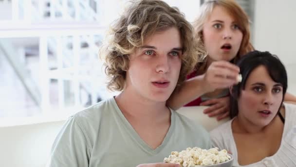 Três Adolescentes Assistindo Televisão Comendo Pipocas — Vídeo de Stock