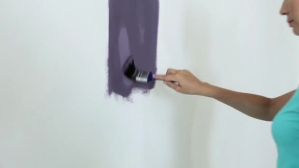 Mujer Joven Pintando Pintura Púrpura Pared Alejar — Vídeos de Stock