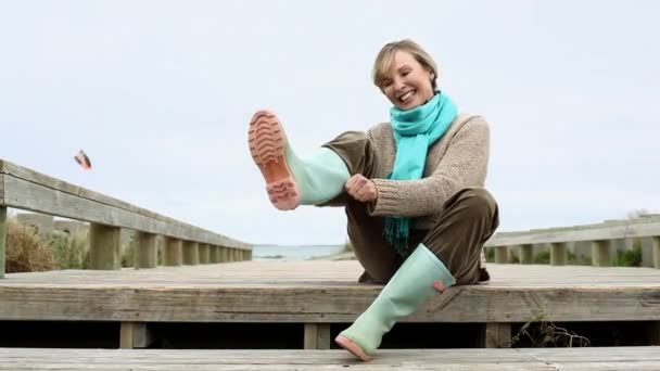 Woman Putting Rubber Boots Wooden Walkway — Stock Video