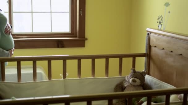 孕妇站在婴儿床旁的侧视图 — 图库视频影像