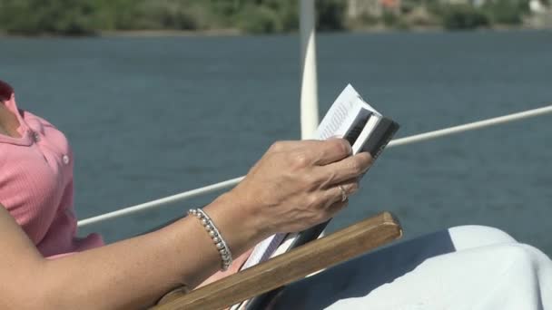 Reife Frau Liest Buch Auf Dem Boot — Stockvideo