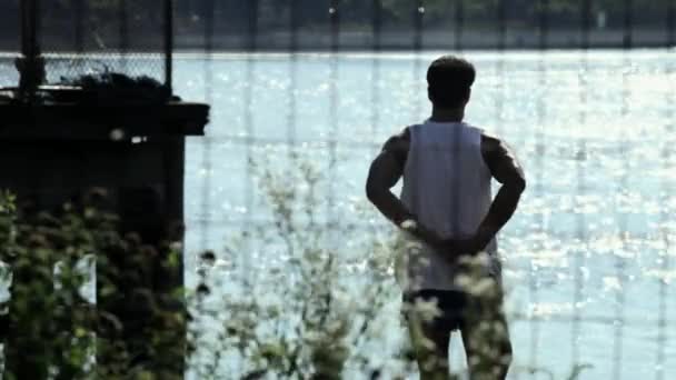 男性ランナー川でストレッチ — ストック動画