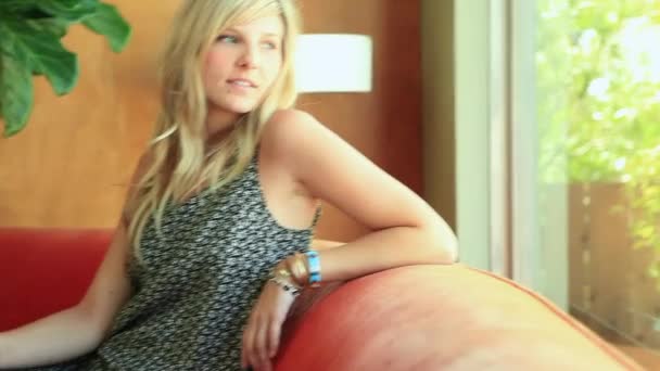 Giovane Donna Seduta Sul Divano Arancione Chiuso Vacanza — Video Stock