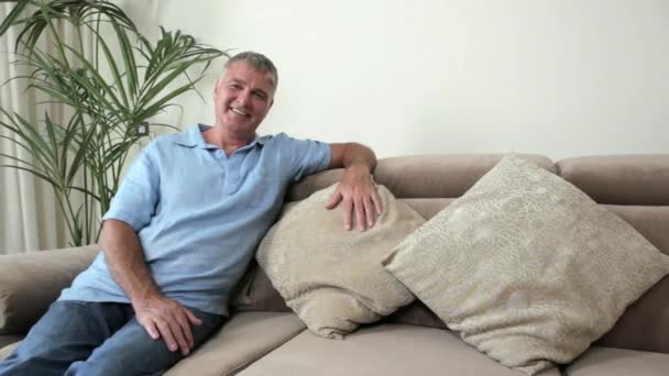 Homem Sênior Relaxando Sofá Olhando Para Longe — Vídeo de Stock
