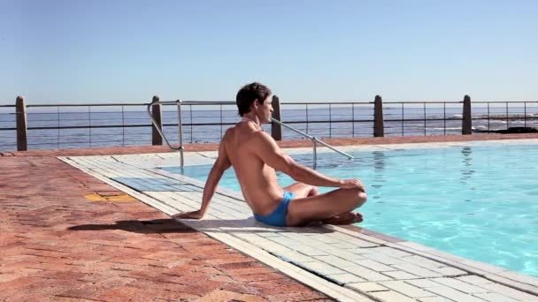 Jovem Sentado Beira Piscina Olhando Para Longe — Vídeo de Stock