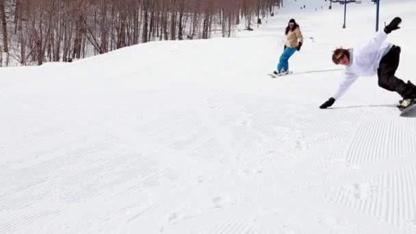 zwei Personen Snowboard bergab