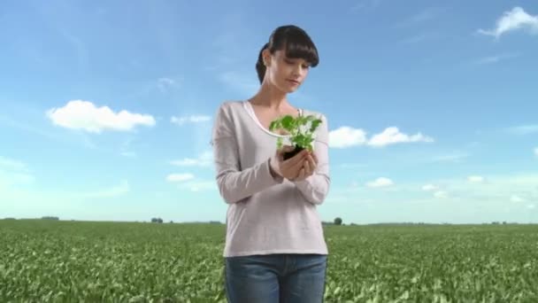 Mujer Campo Sosteniendo Planta Sonriendo Cámara — Vídeos de Stock