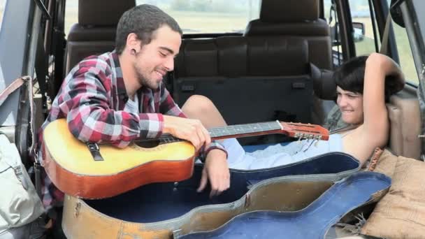 Man Παίζει Την Κιθάρα Για Φίλη Στο Πίσω Μέρος Του — Αρχείο Βίντεο