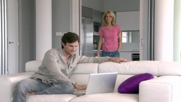 居間でノート パソコンを使用している人のカップル — ストック動画