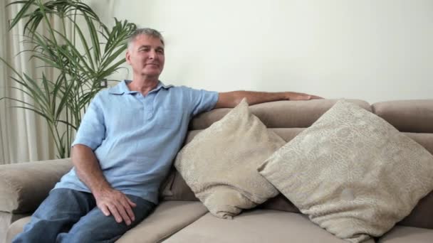 Senior Man Ontspannen Sofa Glimlachend Camera — Stockvideo