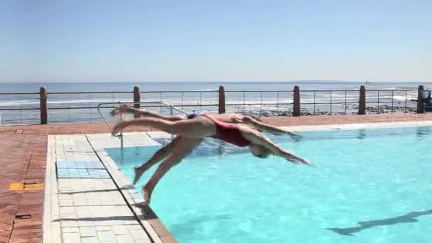 プールに飛び込む若いカップル — ストック動画