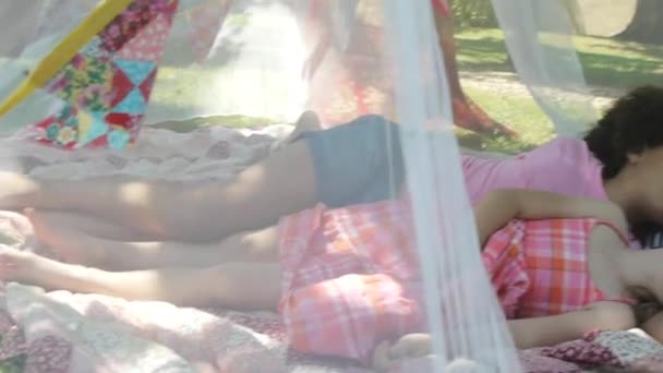 庭の網の下で寝ている子供たち — ストック動画