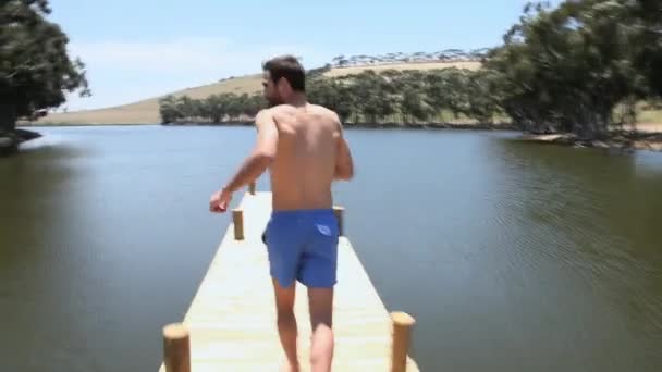 Uomo Che Corre Lungo Molo Salta Nel Lago — Video Stock