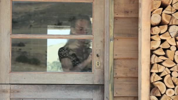 Kobieta Wyglądająca Przez Okno Machająca — Wideo stockowe