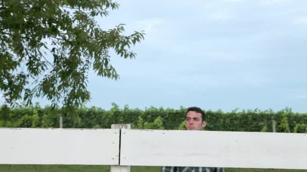 Fröhlicher Mann Lehnt Zaun Auf Ranch — Stockvideo