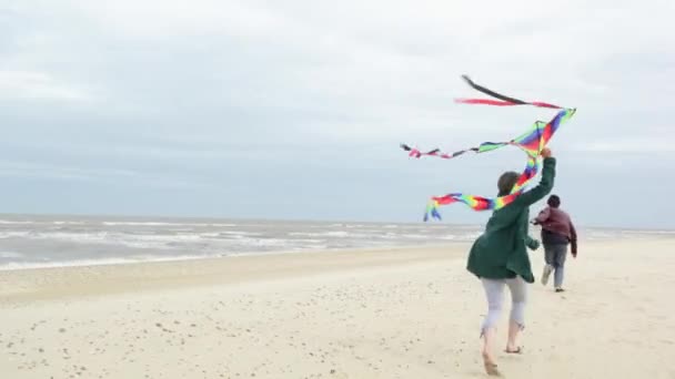 Casal Correndo Com Pipa Voadora Pela Praia — Vídeo de Stock