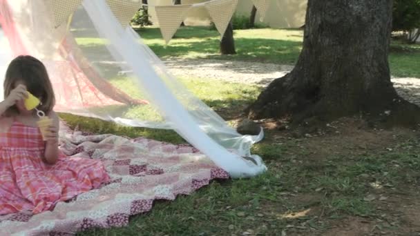 Little Girl Sitting Play Tent Blowing Bubbles — Stock Video