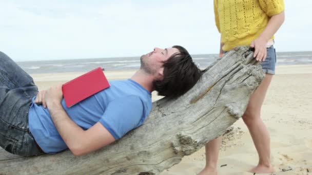 Young Man Lying Driftwood While Girlfriend Coming Kissing Him — Stock Video